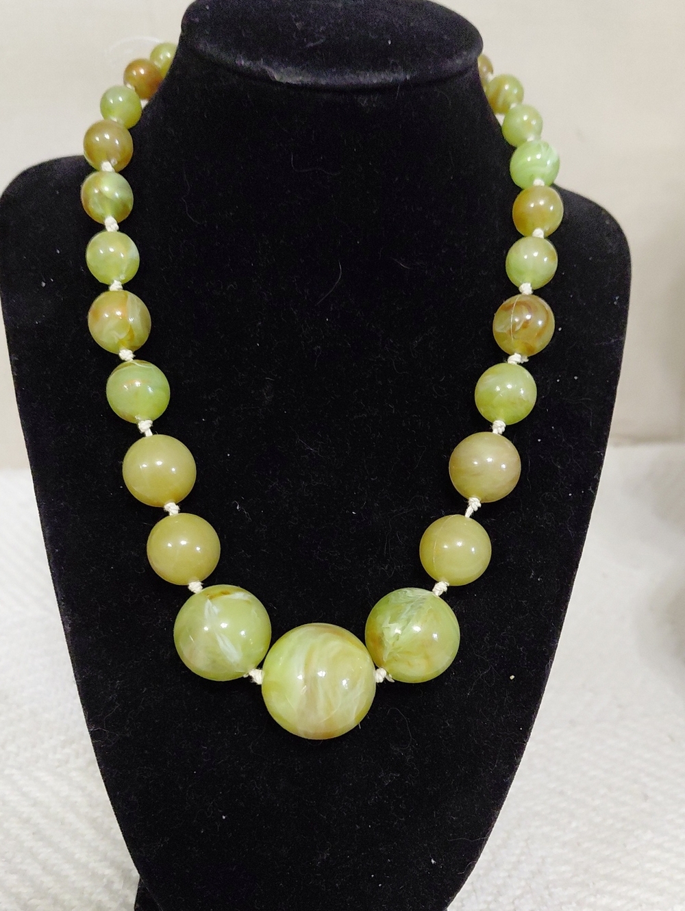 A Vintage Graduated Necklace of Green Resin or Bakelite Beads